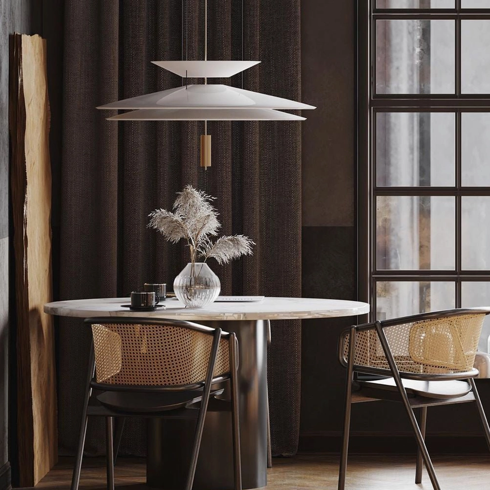Single Hover Disc chandelier in small round dining area with warm neutral modern decor and dark curtain backdrop