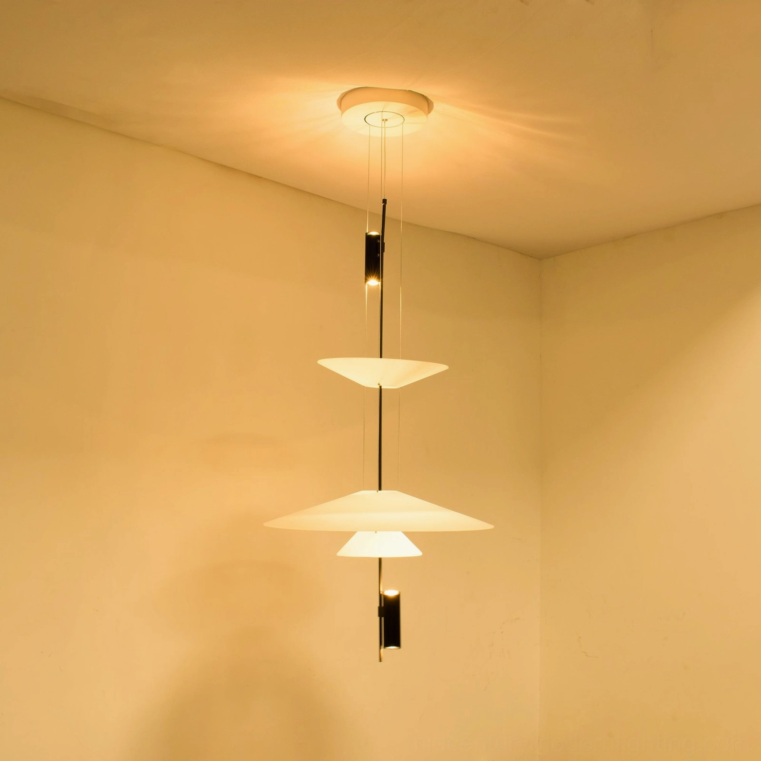 Hover Disc pendant chandelier low-angle view showing geometric balance of suspended discs and counterweight