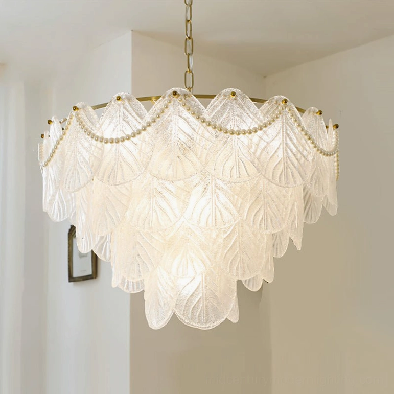 Front oblique view of illuminated tiered glass leaf pendant lamp with warm lighting in modern white interior, sculptural mid-century botanical design