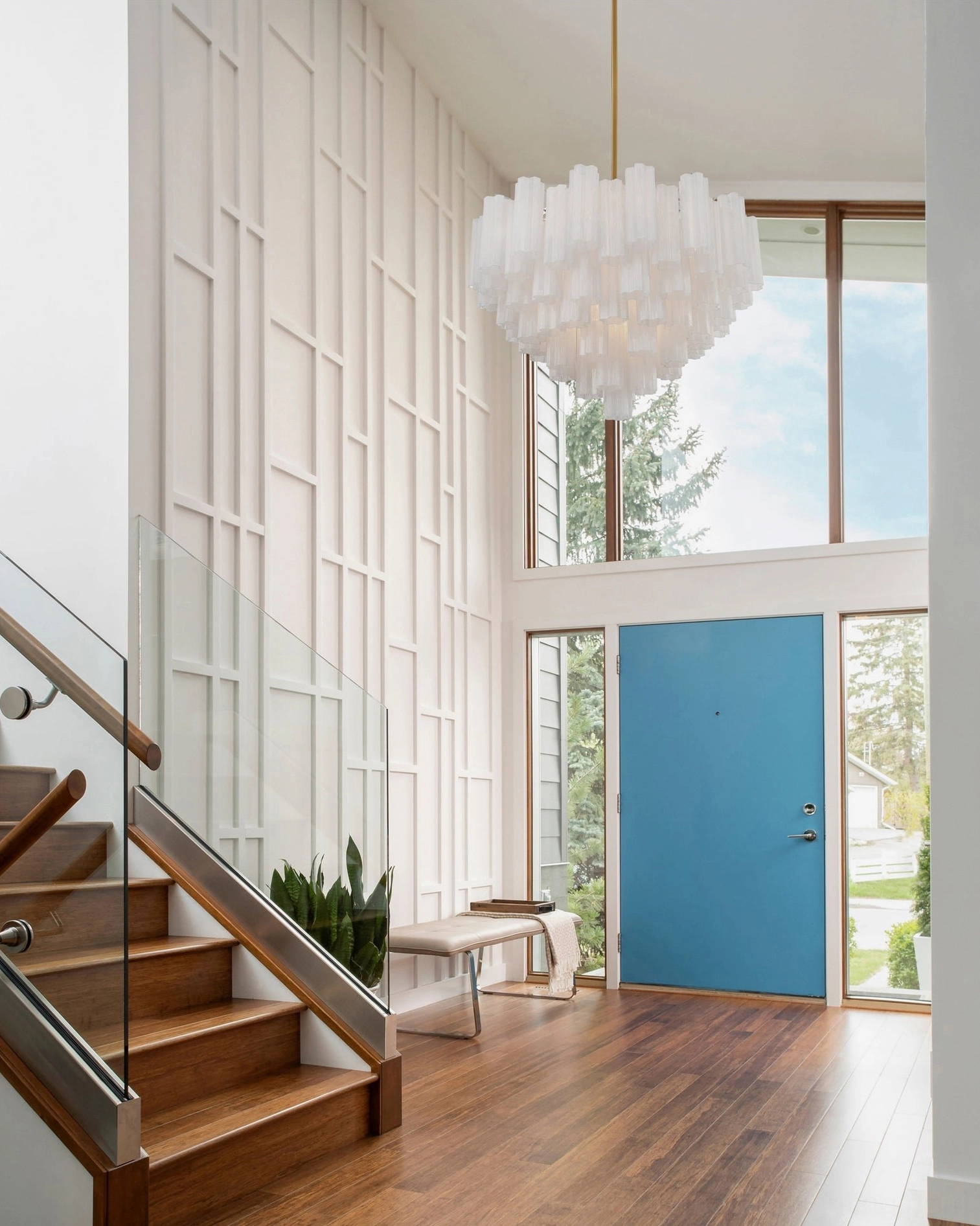 White frosted Murano glass chandelier in modern minimalist double-height entryway with staircase