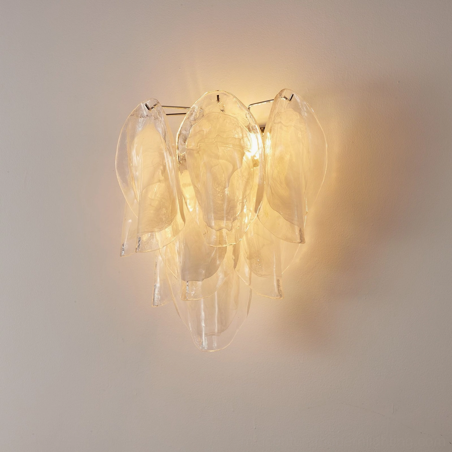Ina petal wall light illuminated with warm ambient light creating soft shadow effects