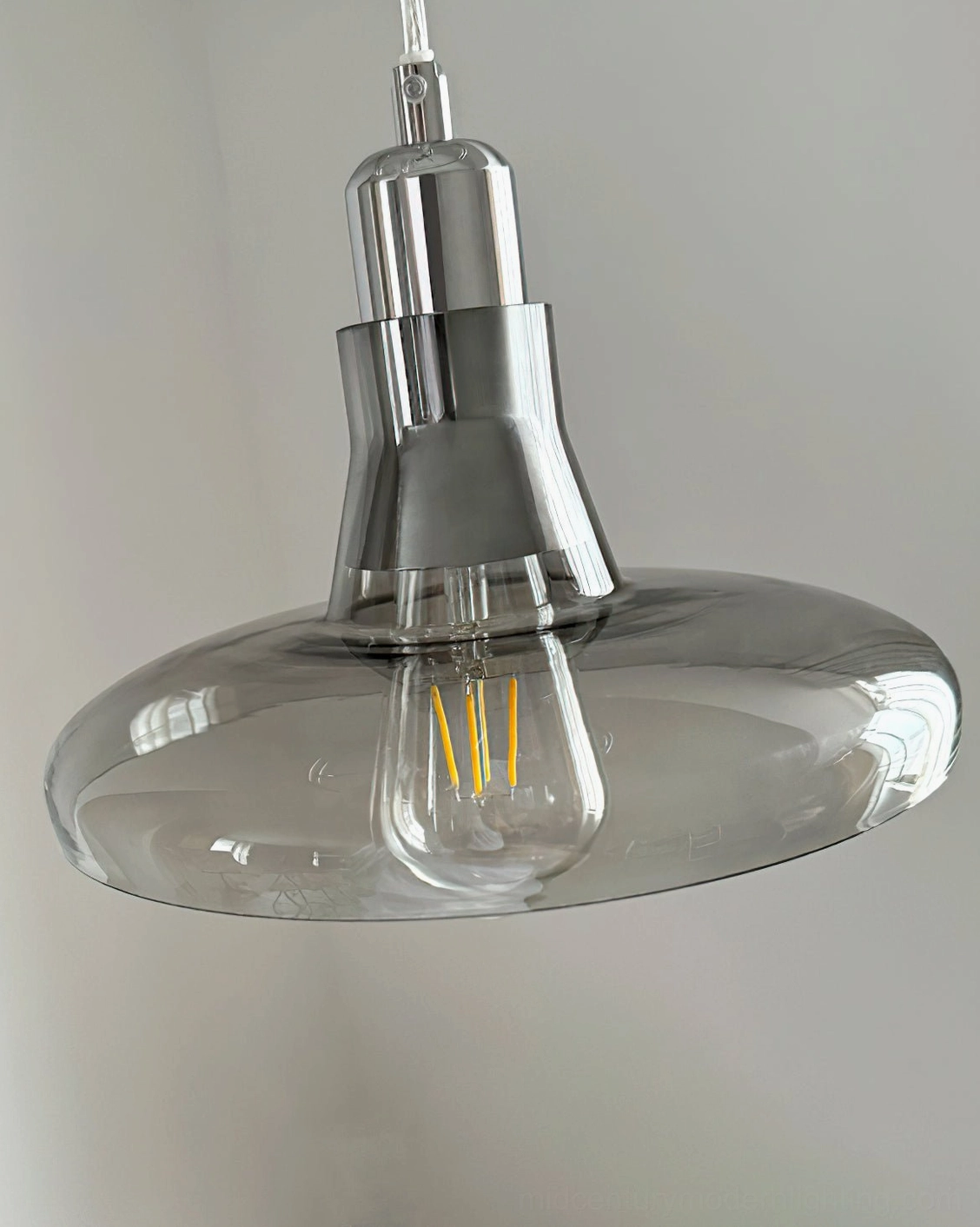 Industrial pendant bottom close-up view featuring smoked glass shade with polished silver base and metal hardware