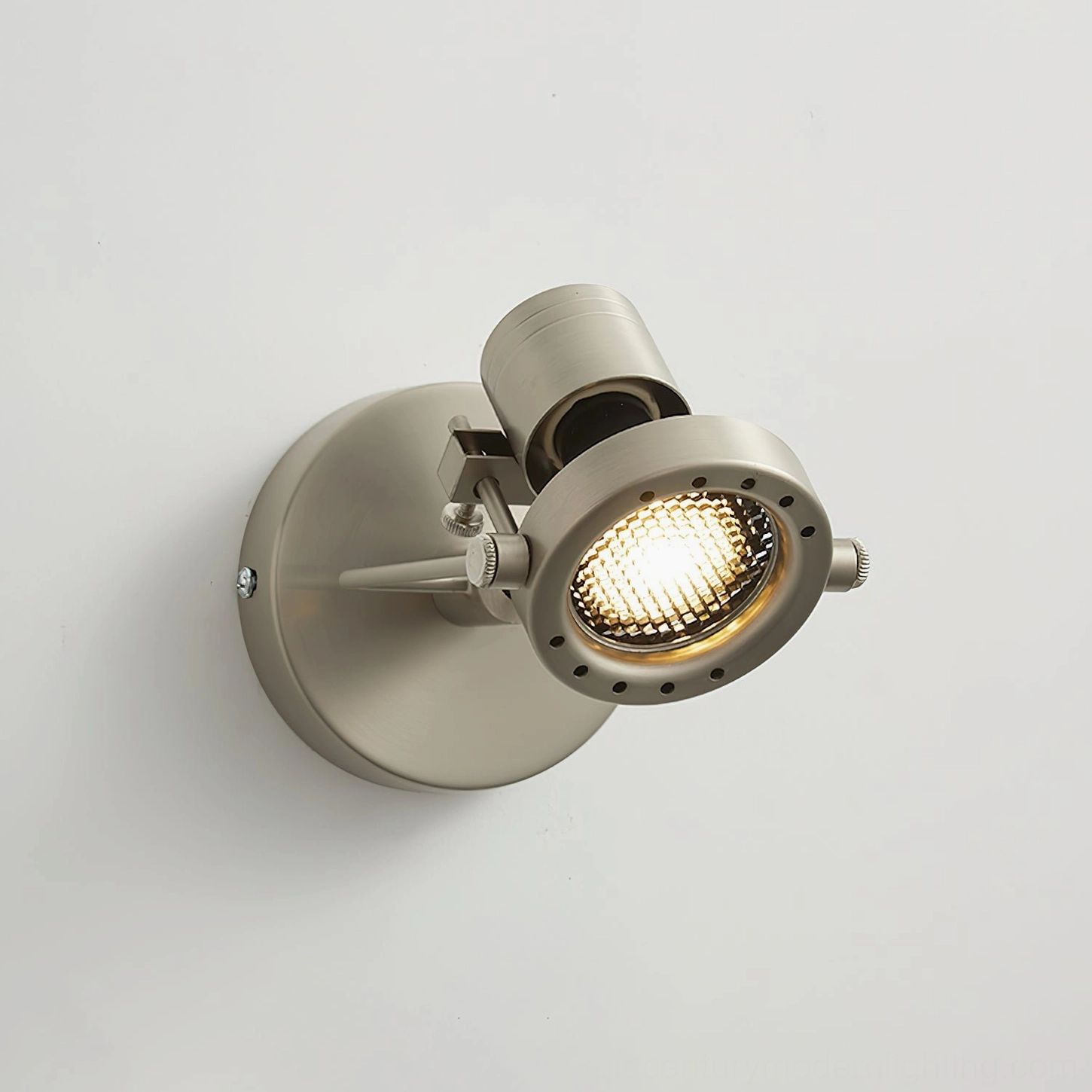 Front view of industrial wall spotlight with perforated metal lamp frame and warm light emission