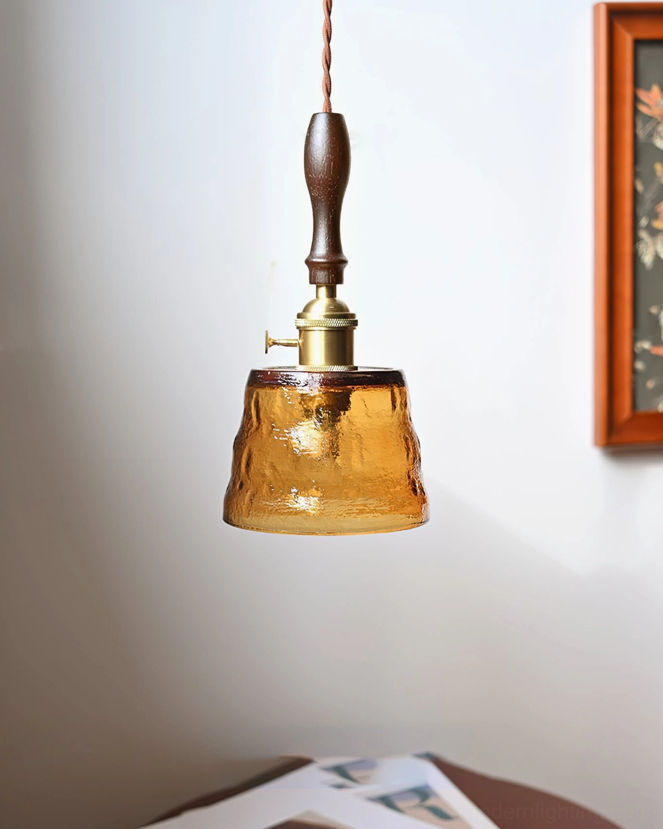Jace amber glass pendant with twisted fabric cord in residential wall setting