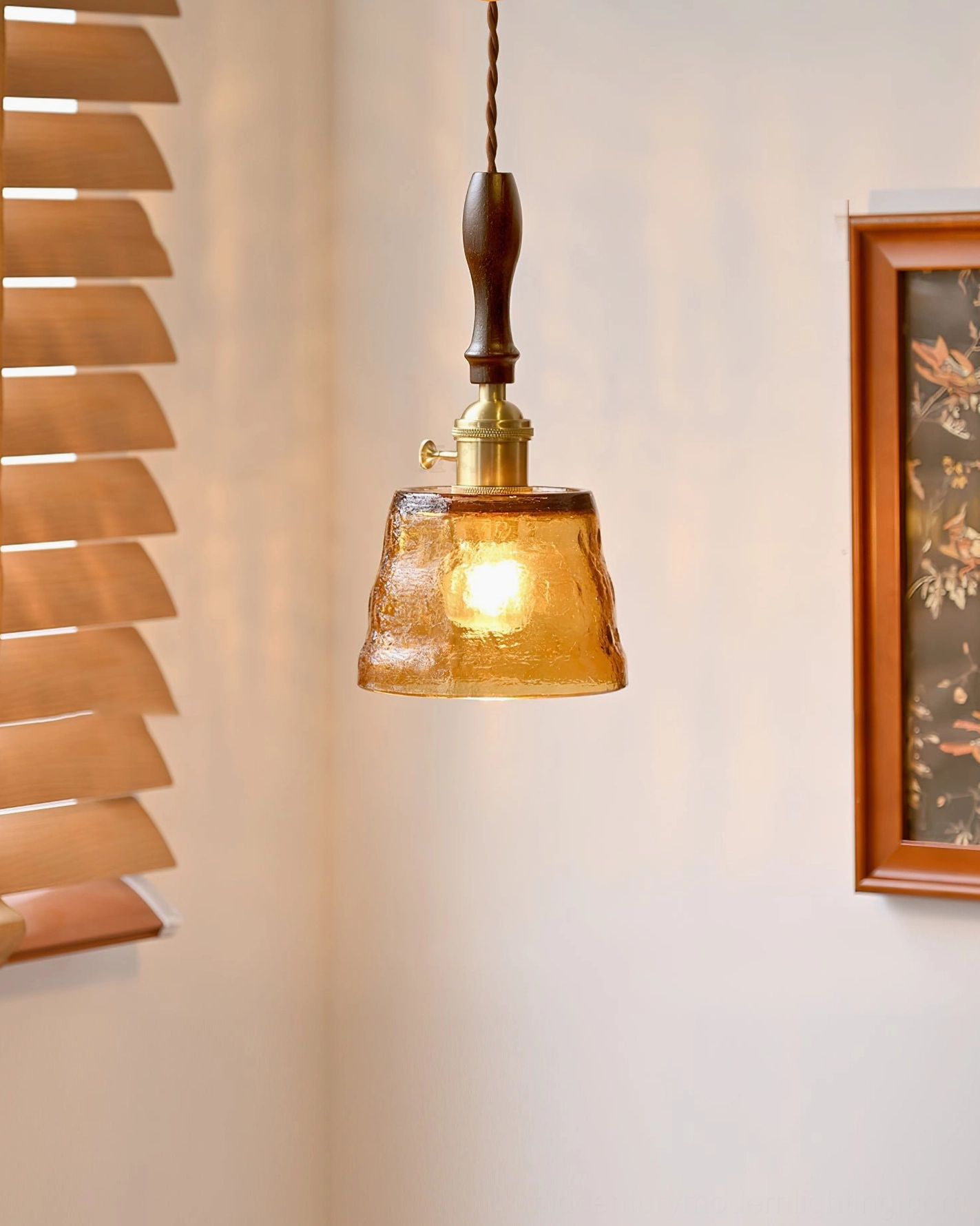 Jace pendant lamp close-up showing hammered amber glass texture and glowing LED bulb