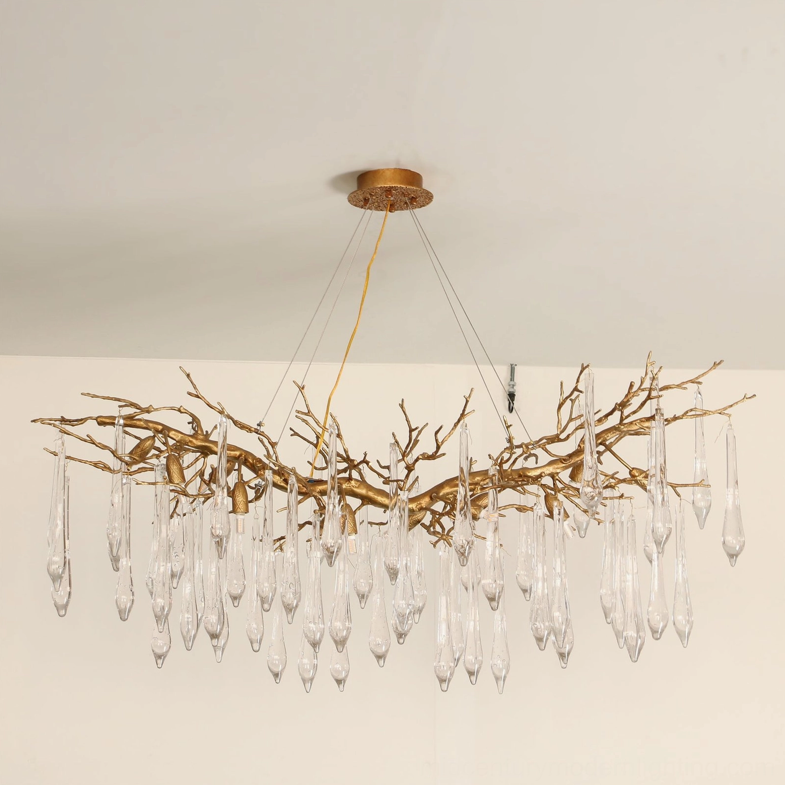 Janae crystal chandelier close-up detail showing exposed G9 bulbs, glossy clear teardrop crystals, and warm light glow