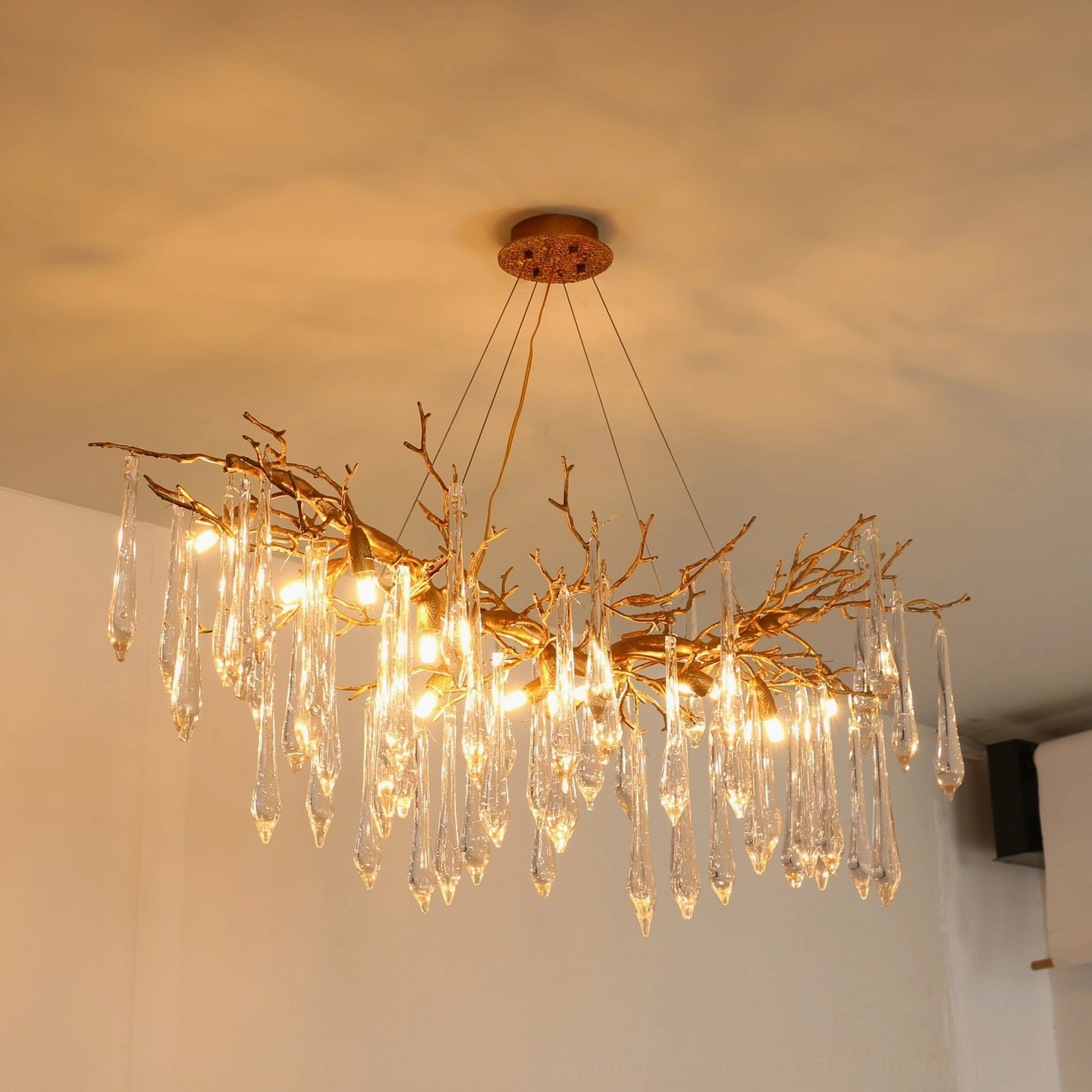 Janae chandelier overhead view against plain white ceiling studio background, unlit frosted teardrop crystals visible