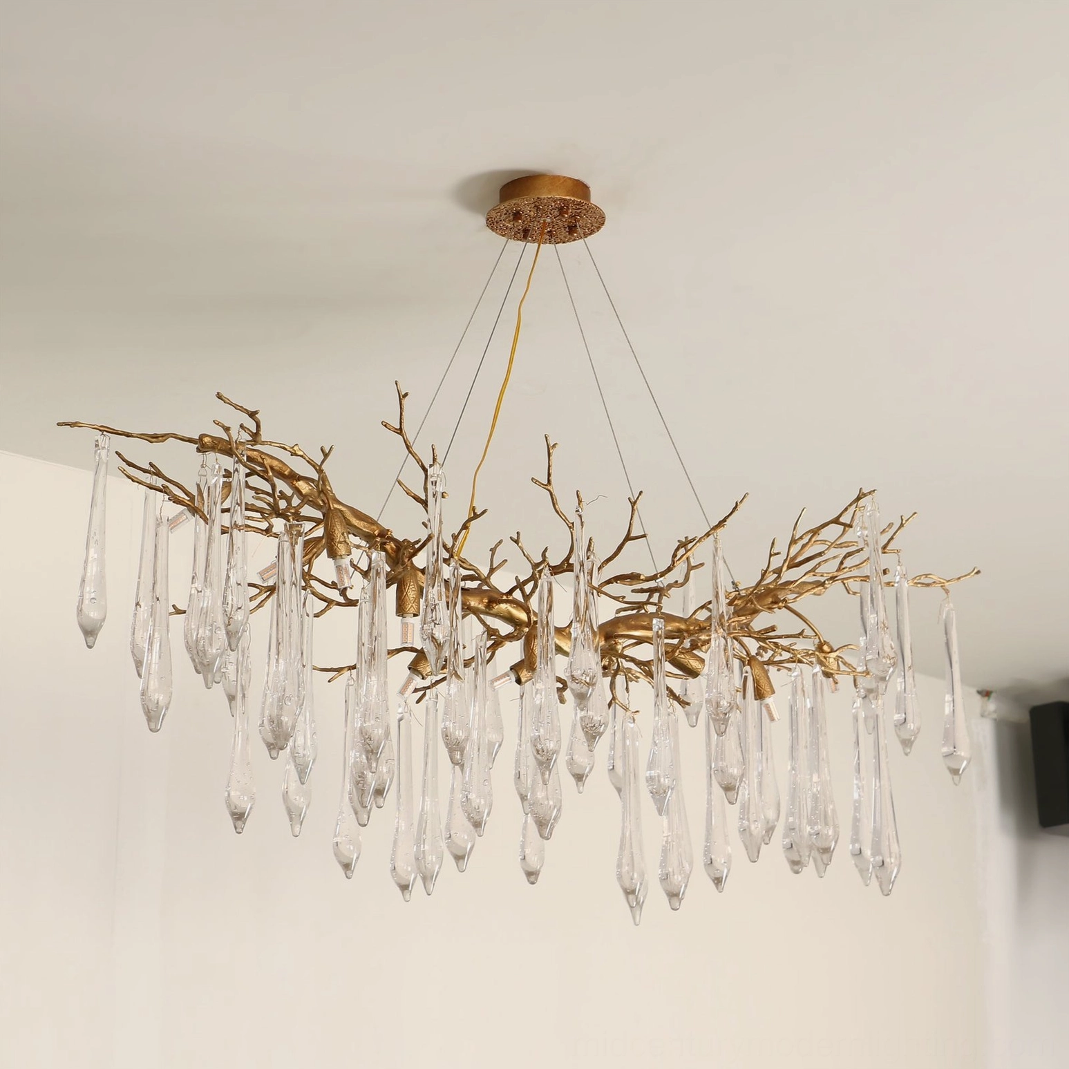 Janae branch-style chandelier low-angle side view with opaque frosted pendants and antique gold brass frame lighting fixture
