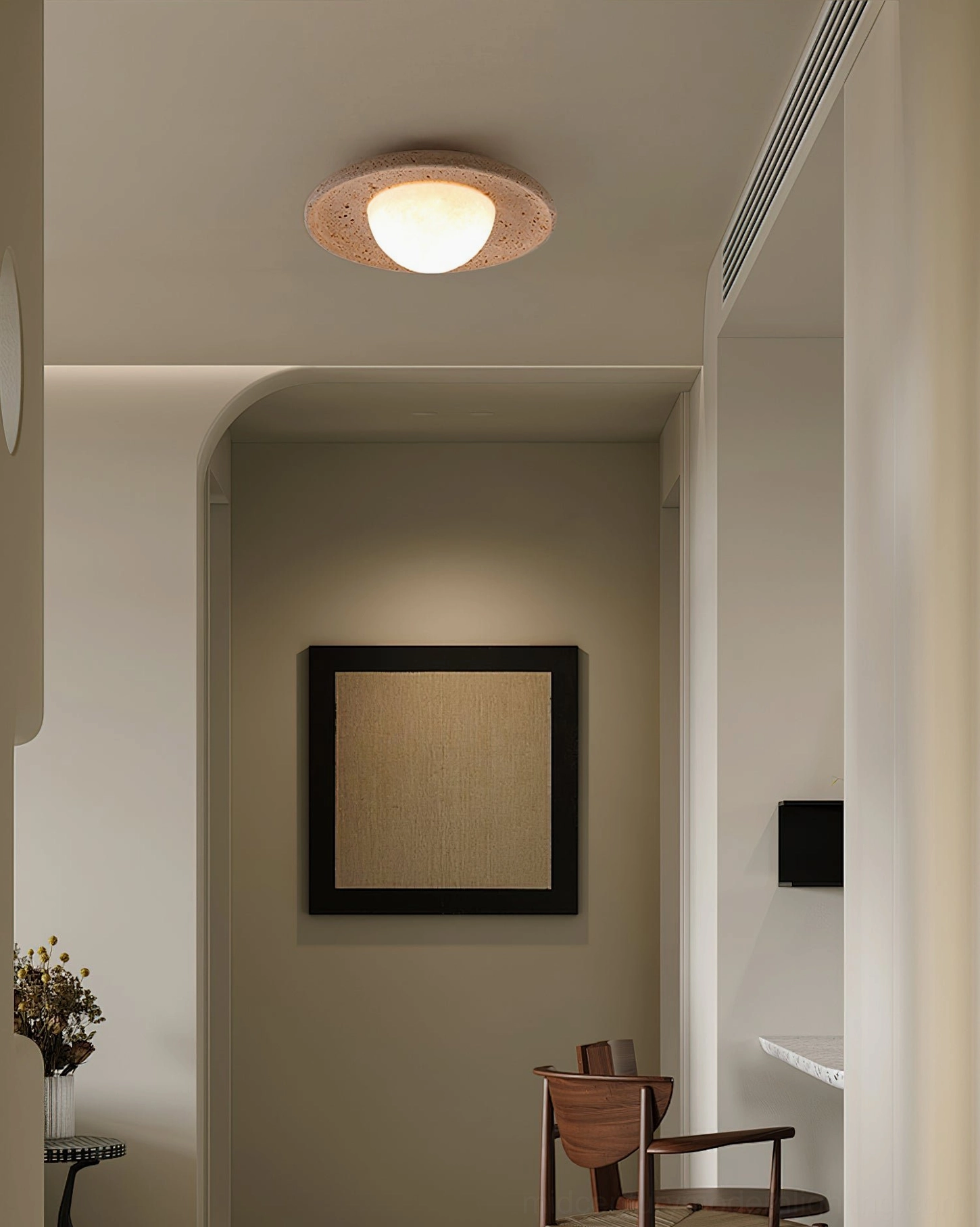 Single Jenny travertine ceiling light illuminating contemporary minimalist residential hallway with warm glow
