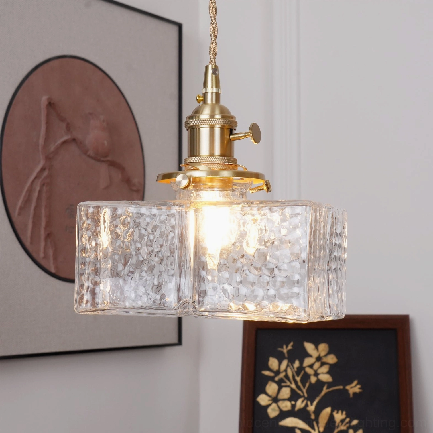 Jewel brass pendant light suspended over dining table in mid-century inspired interior with warm ambient lighting