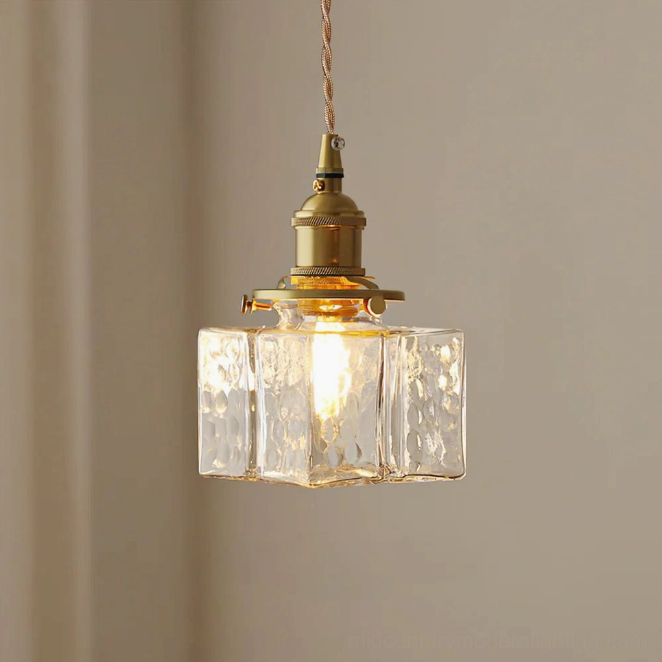 Close-up front view of jewel brass and clear glass pendant light - Model A square design showing hammered glass texture and brass base