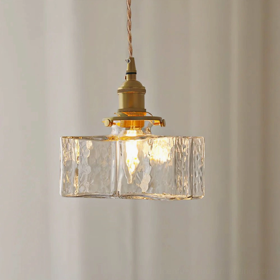 Jewel brass and clear glass pendant light - Model B wide rectangle design suspended in studio with off-white background