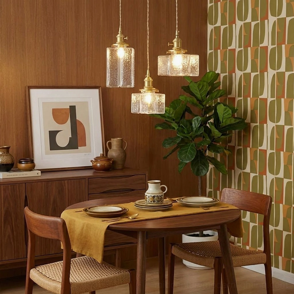 Three jewel brass pendant lights suspended in wood-paneled mid-century dining room with retro boho style furnishings