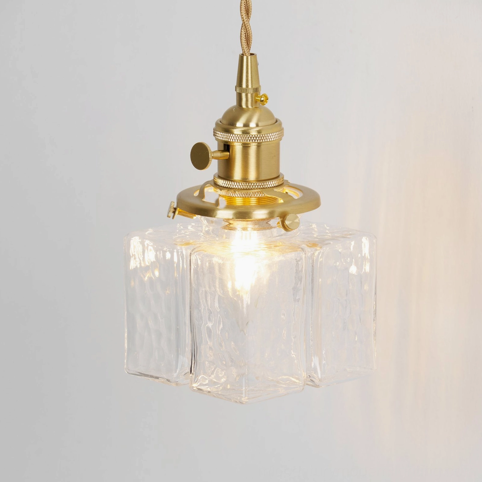 Jewel glass brass wall lamp warm metallic finish textured glass shade close-up detail