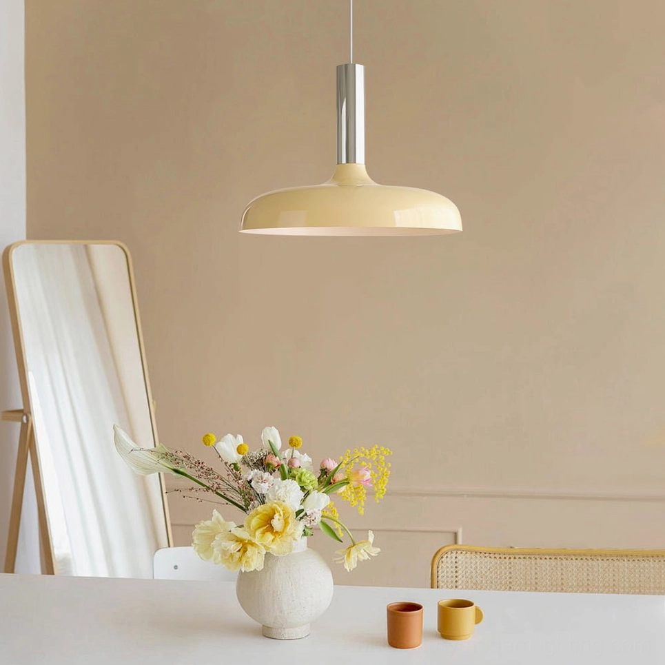 Julia modern pendant lamp cream shade with silver metal fixture displayed above dining table, low-angle view emphasizing sculptural geometry