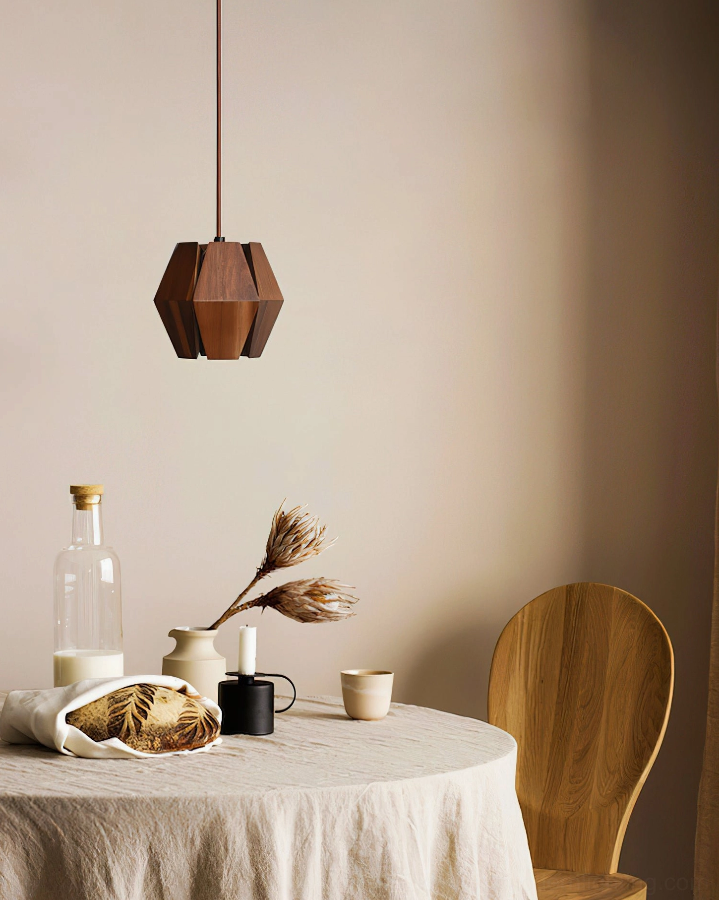 Kaden faceted wood pendant casting warm shadows over casual round dining table setting