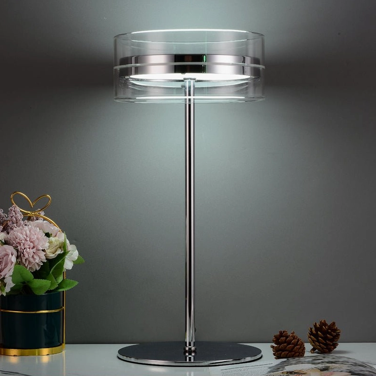 Modern cylindrical table lamp with polished chrome base on console table, cool white LED light