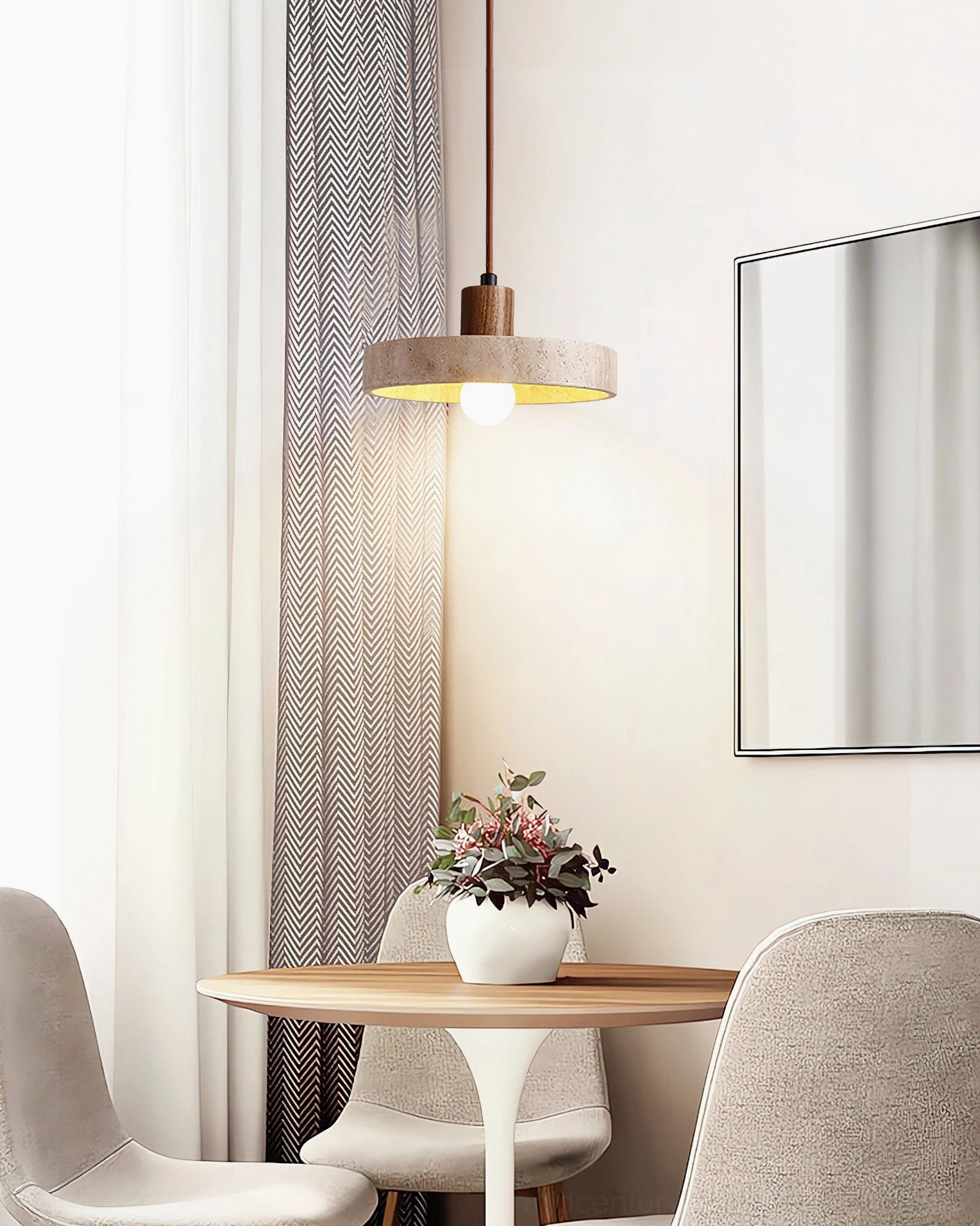 Kairi travertine pendant suspended above round dining table in modern minimalist dining room