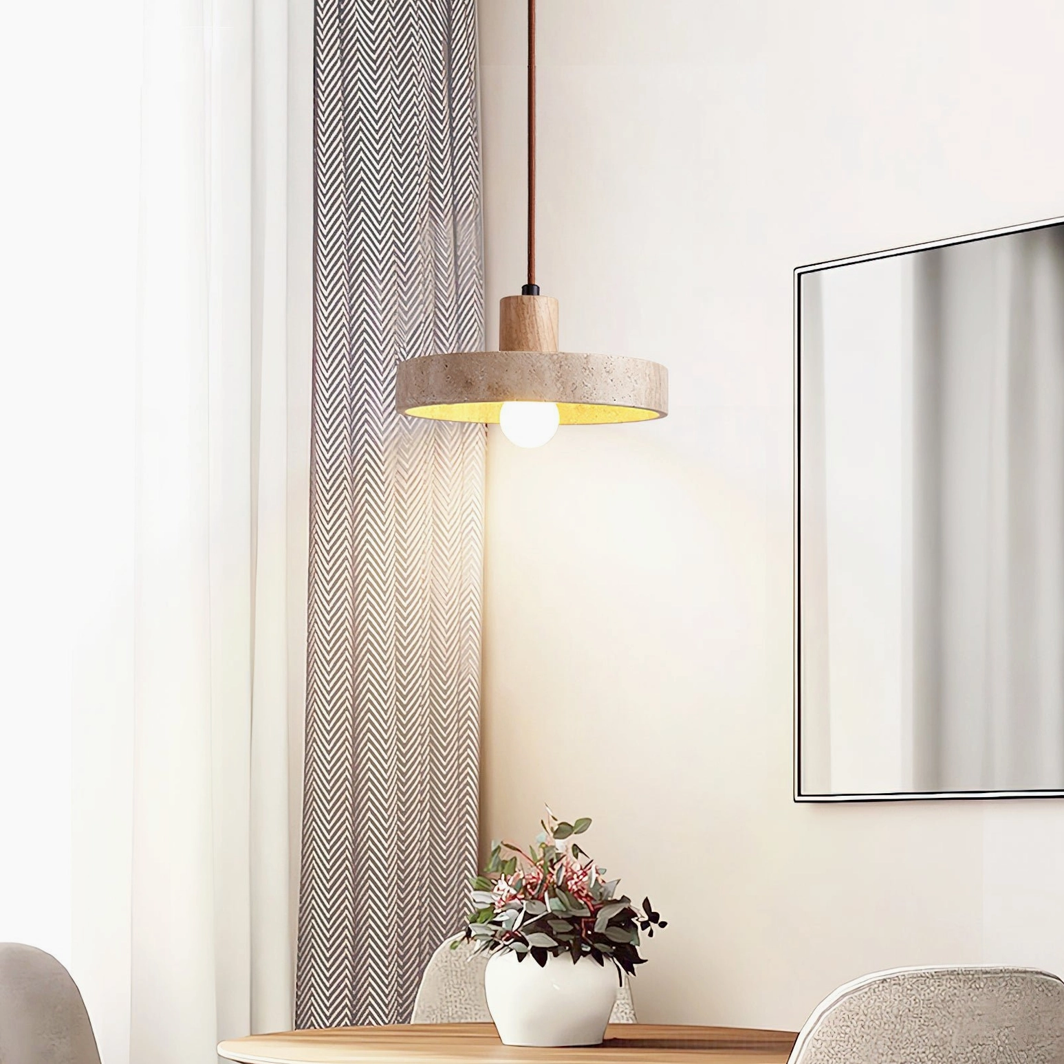 Single Kairi pendant light suspended above dining table with potted flowers home decor styling