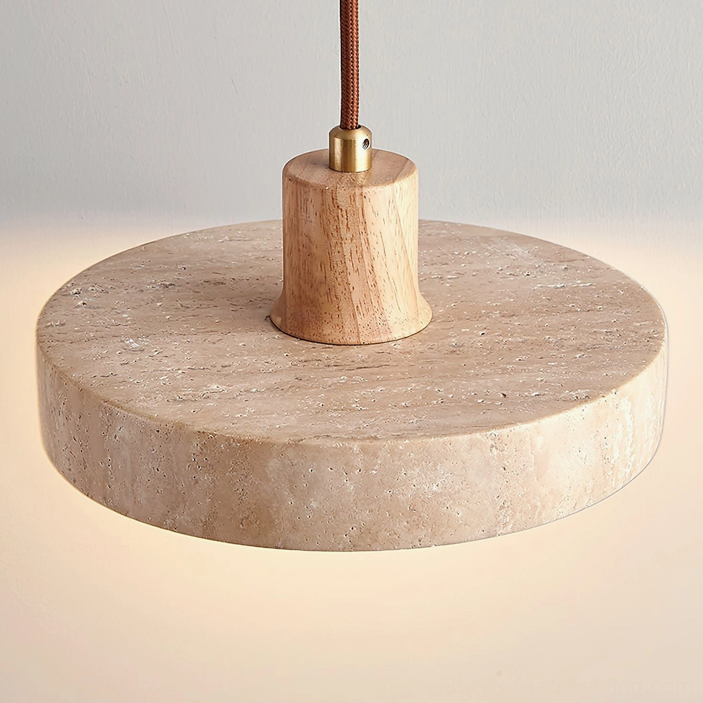 Kairi stone pendant shade illuminated showing warm light diffusion through travertine material