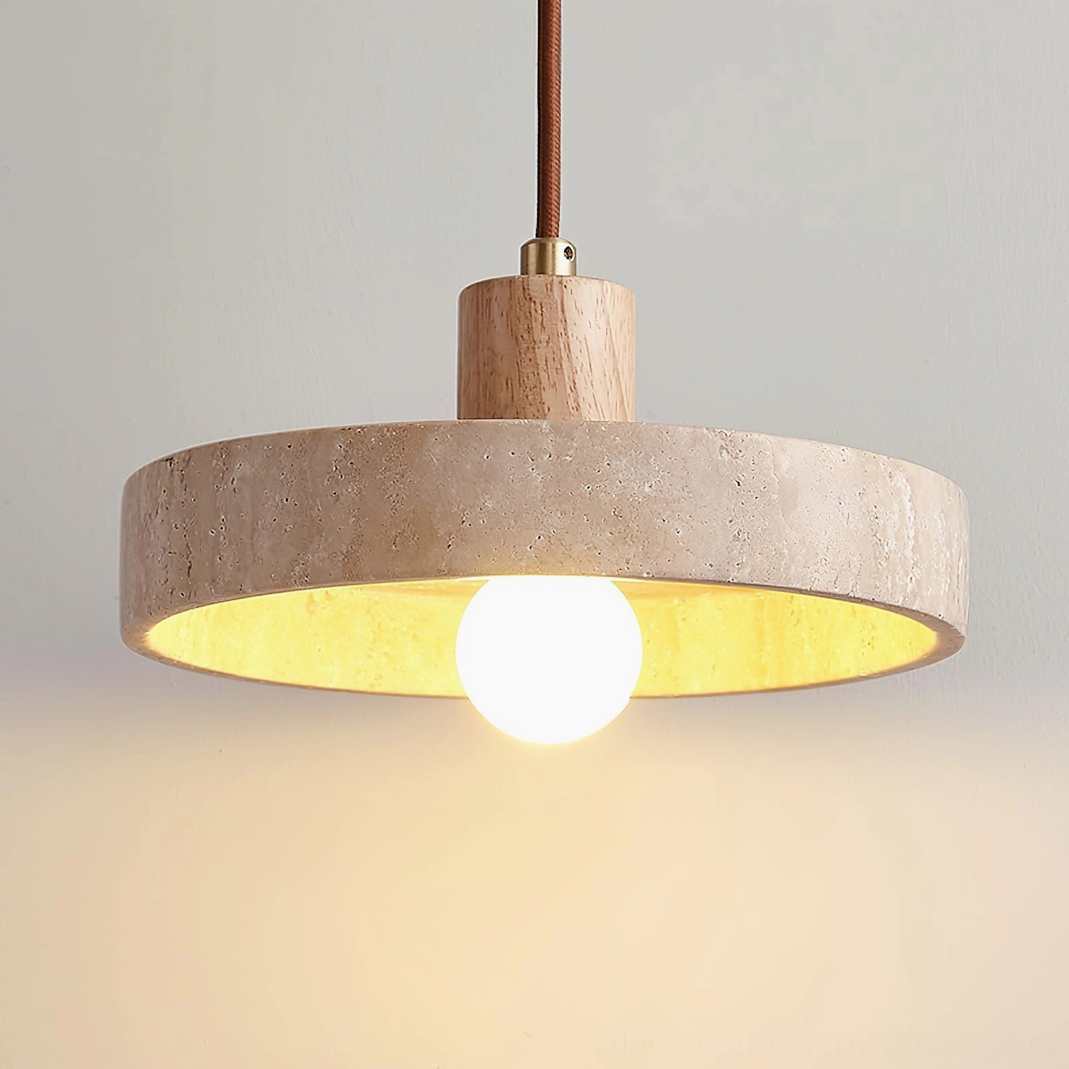 Kairi travertine pendant light construction showing metal hardware and mounting system