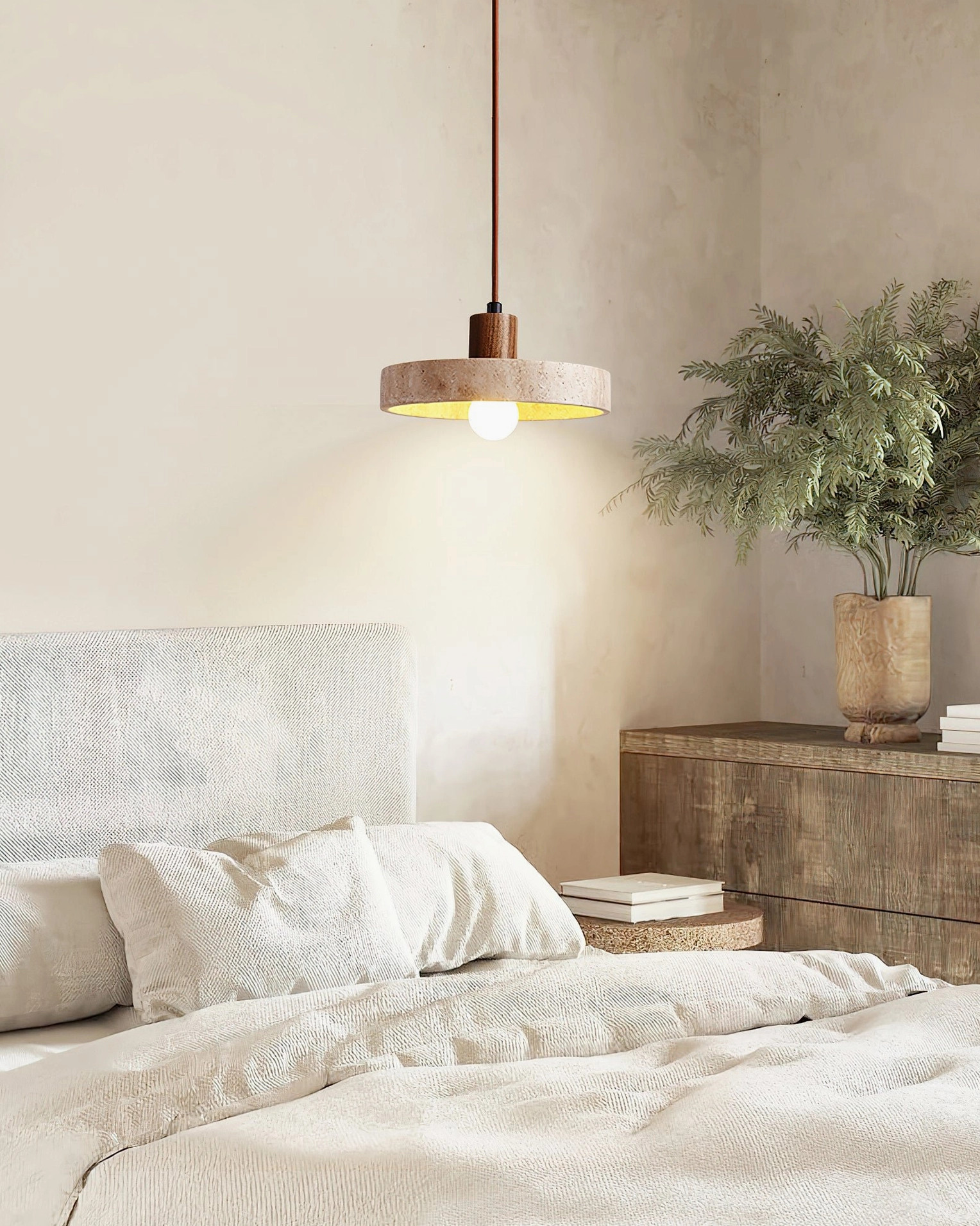 Kairi travertine pendant lamp mounted in minimalist bedroom with warm neutral interior design