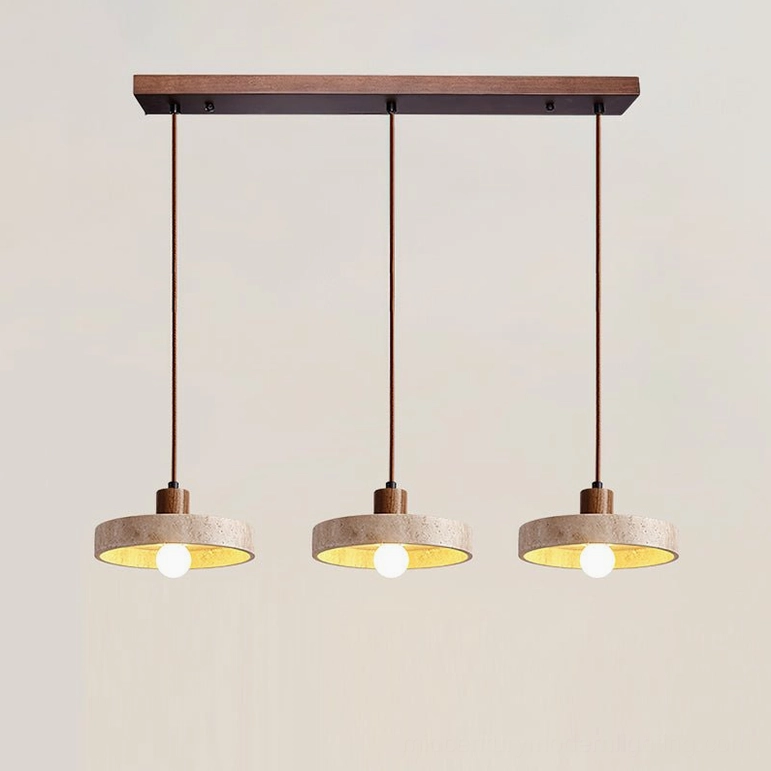 Three Kairi travertine pendants in walnut finish creating cohesive lighting design over dining area