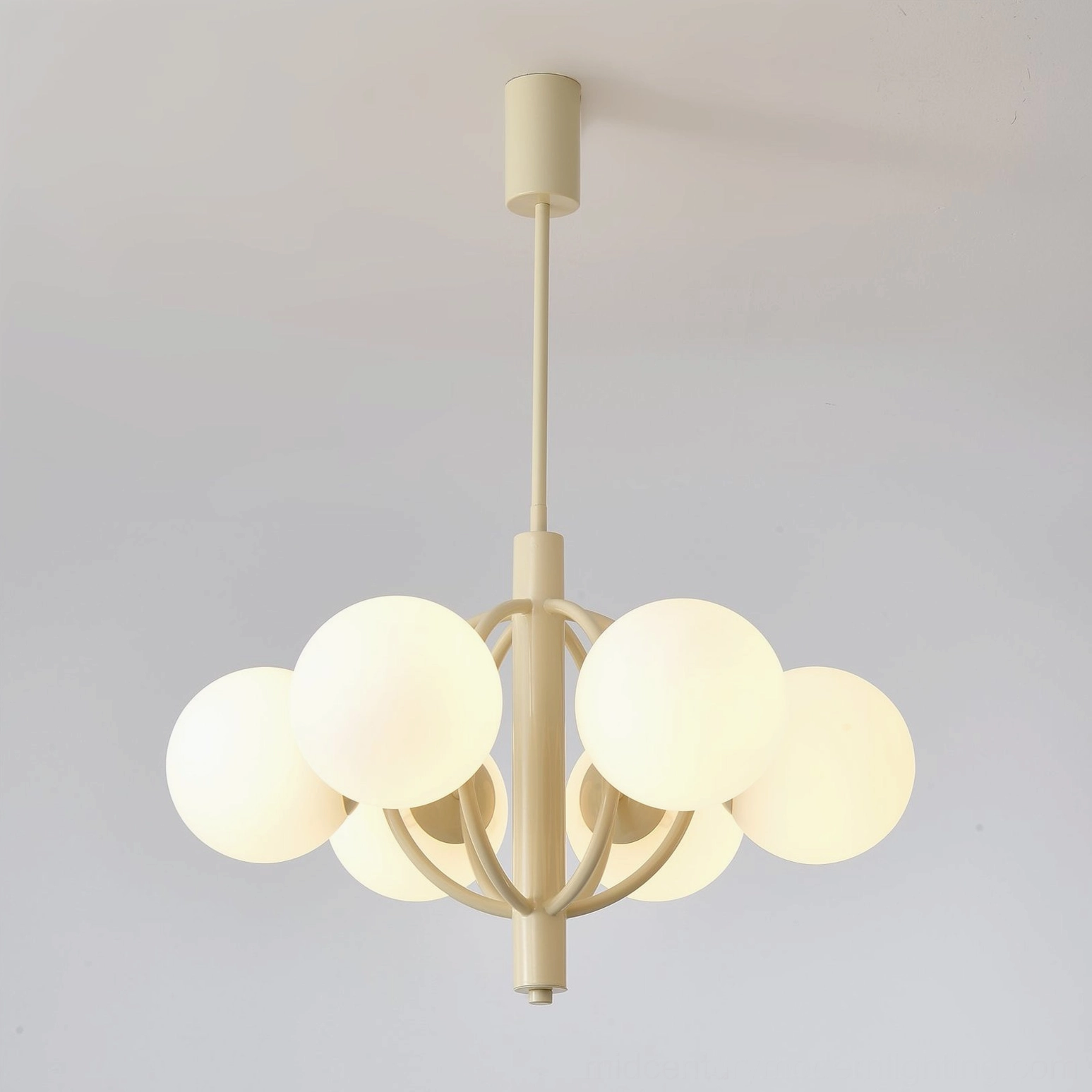Kaiser chandelier illuminated, showing warm glow through frosted glass shades and cream metal arms