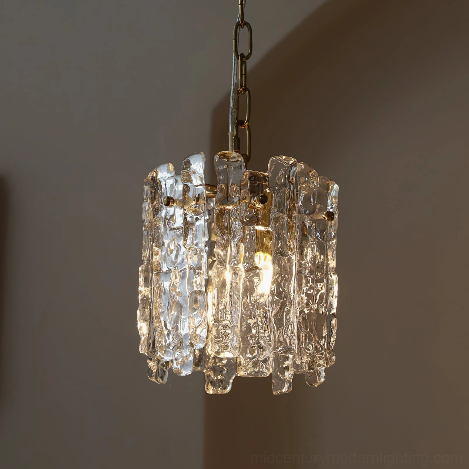 Kalmar textured glass pendant light showing geometric arrangement of layered panels with brass metal support structure