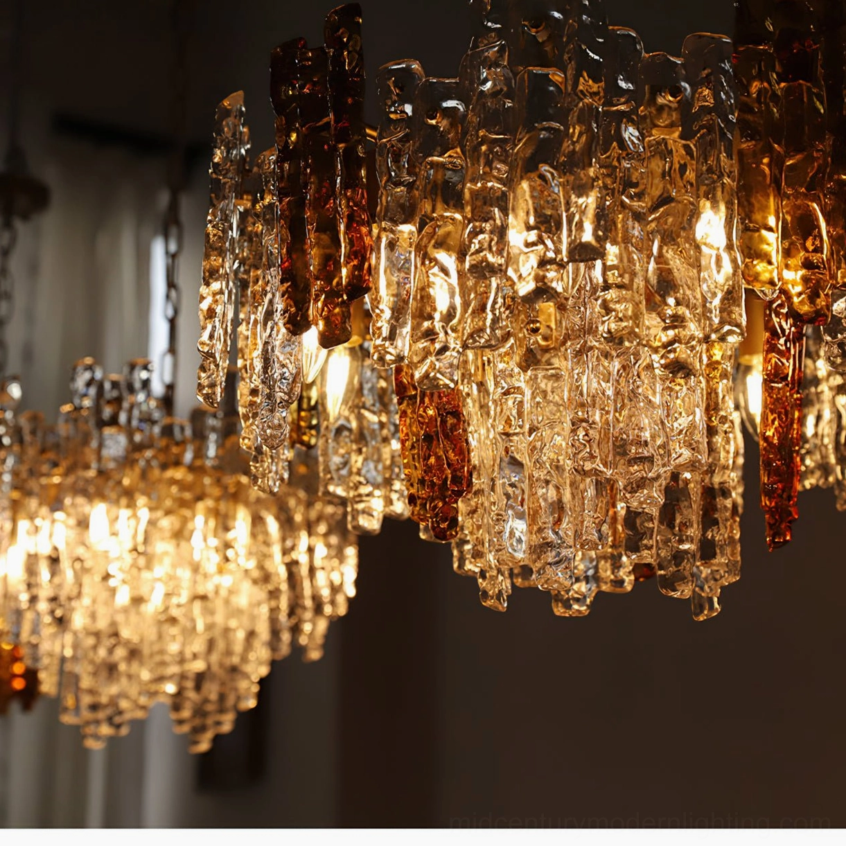 Multiple lit Kalmar ice glass chandeliers creating opulent warm interior ambiance with fully illuminated layered glass panels