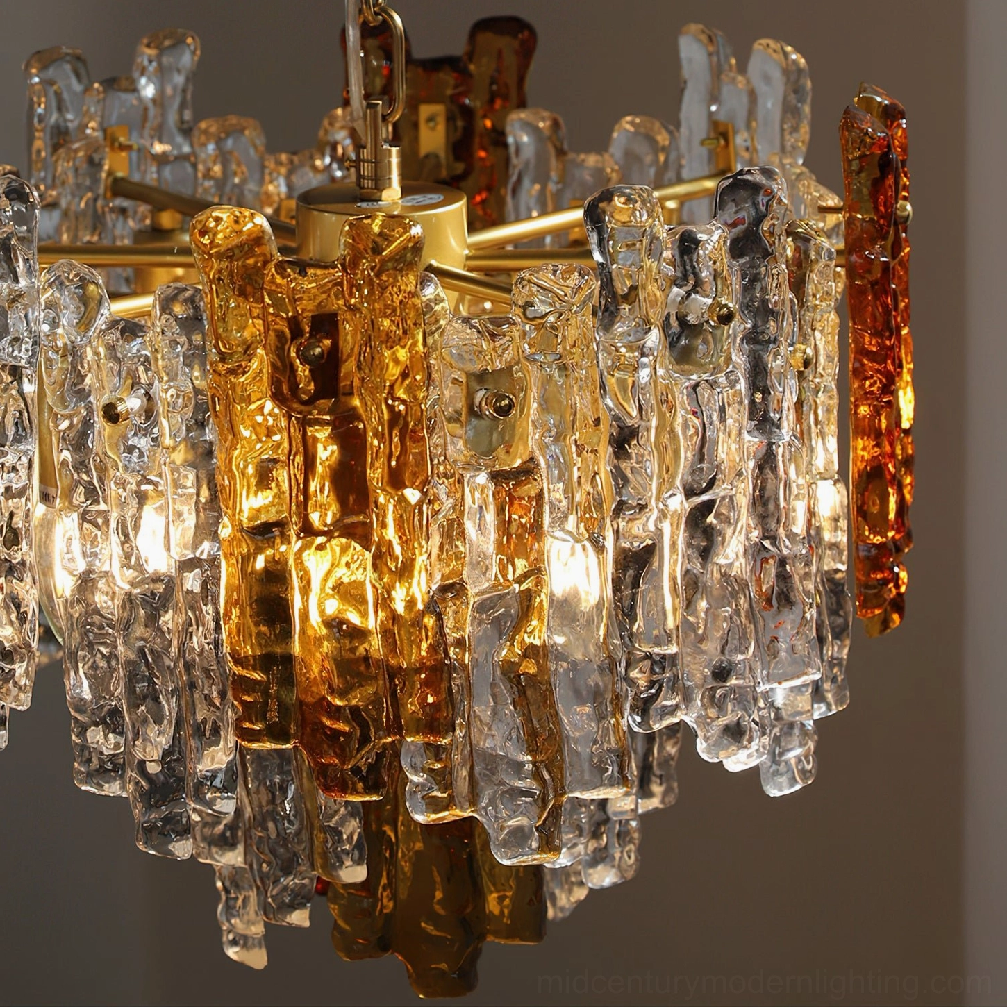 Close-up overhead view of Kalmar pendant light showing detailed textured glass with clear and amber tones and gold metal fixture