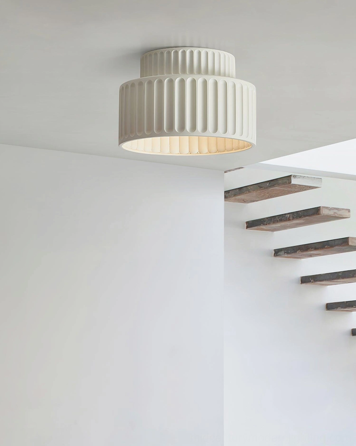 Off-white Kami two-tier ribbed ceiling lamp in modern home stairwell, low-angle perspective with neutral matte tone