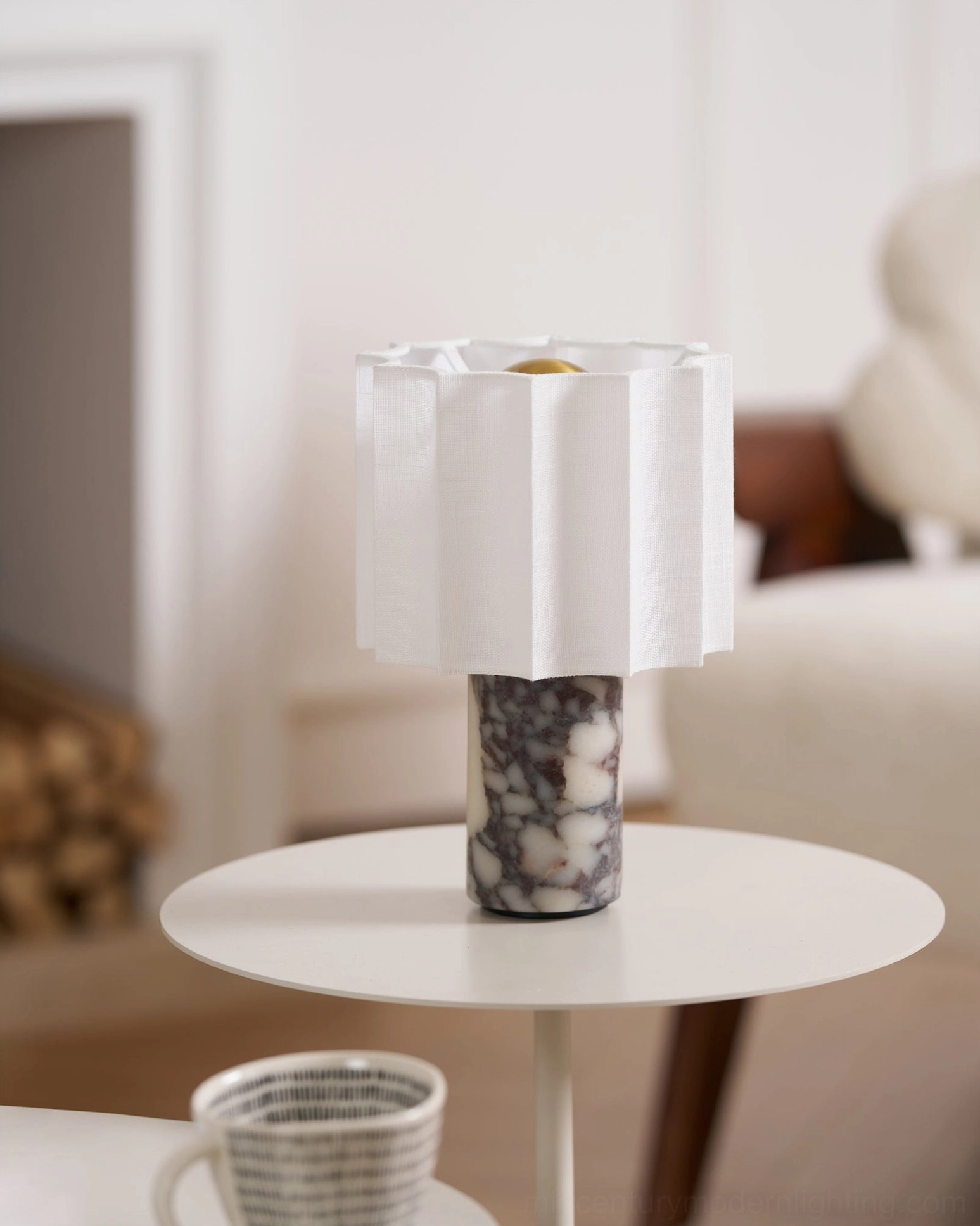 Unlit Kane cordless marble table lamp on minimalist living room side table, white pleated shade with dark floral-veined marble base