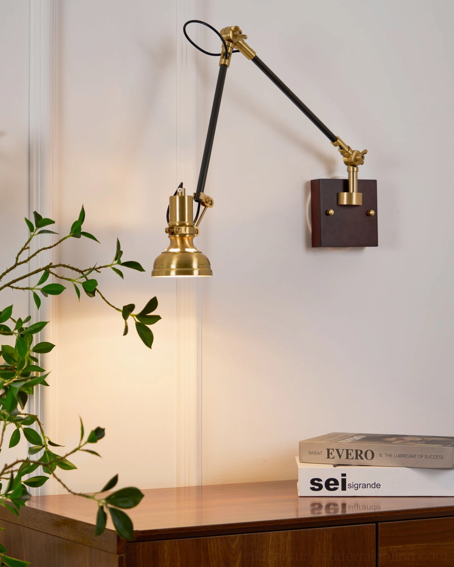 Kane Swing Arm Wall Lamp mounted in modern bedroom next to leather furniture