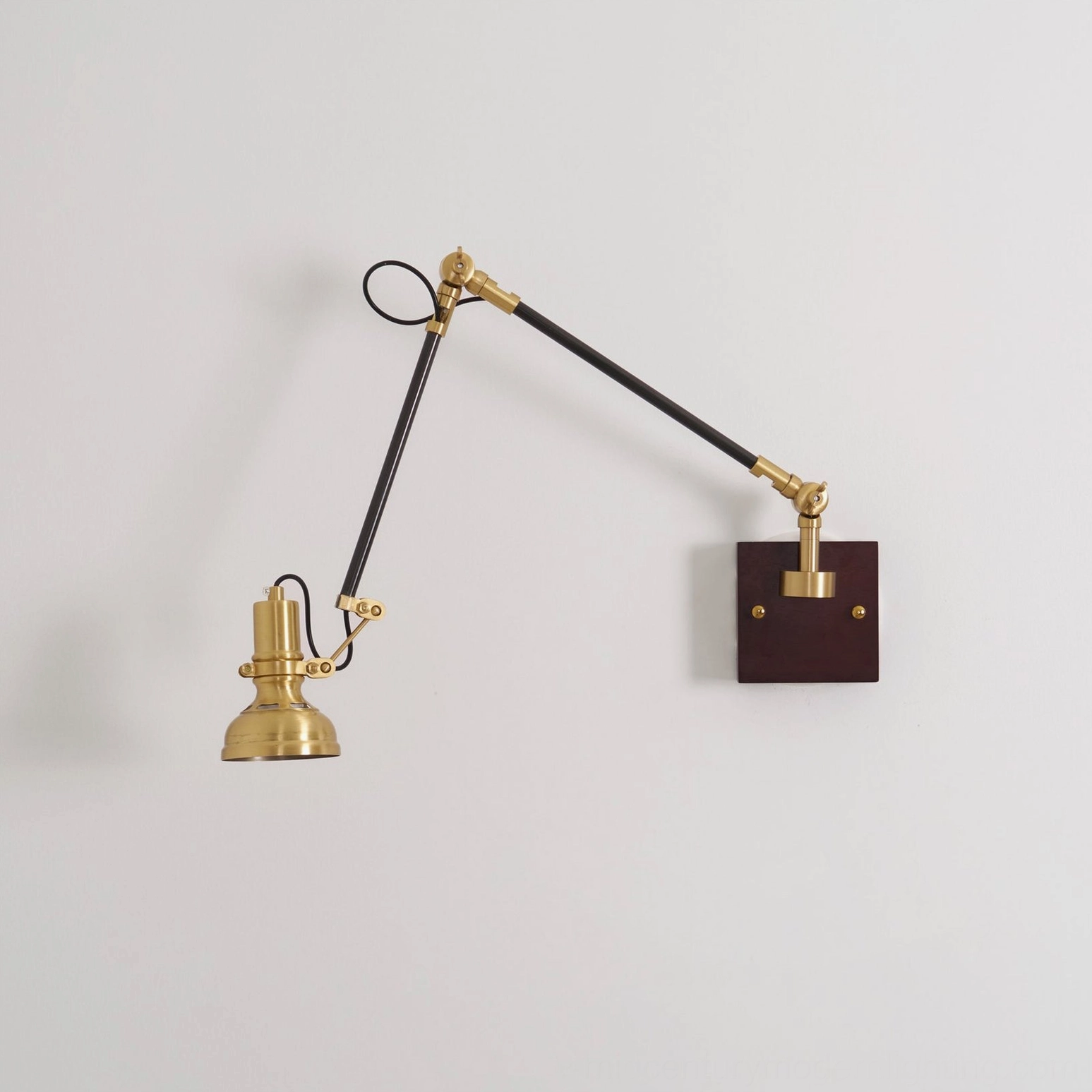Kane Swing Arm Wall Lamp installed in mid-century modern interior with leather seating