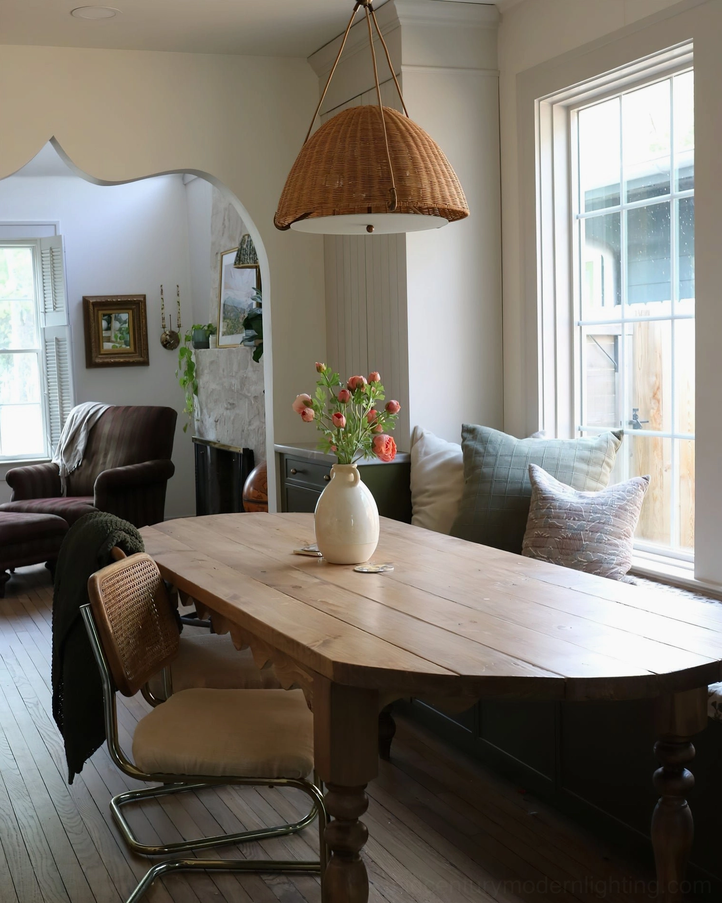 Kash rattan dome pendant light above farmhouse dining table in wooden nook setting