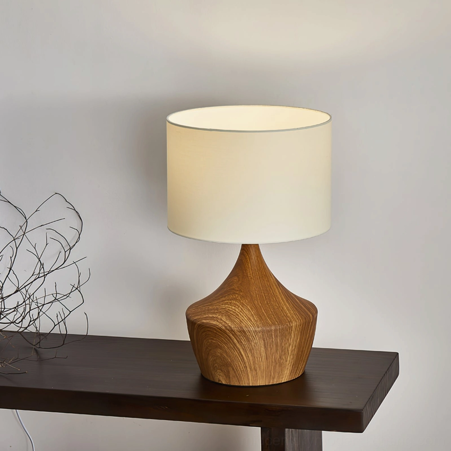 Kendra table lamp three-quarter angle view with warm light ambient glow on console table