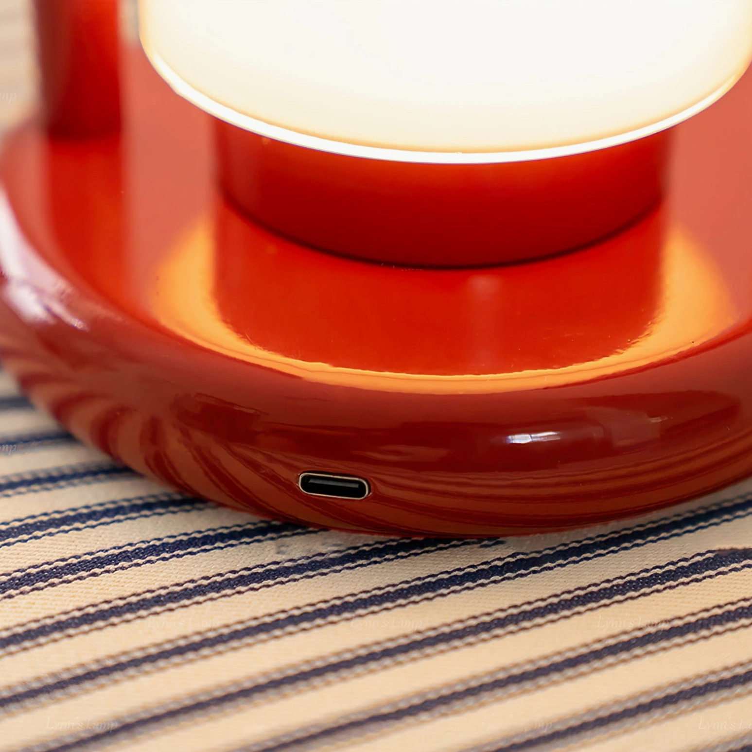 Close-up detail of Kero lamp base showing glossy red metal finish and USB-C charging port