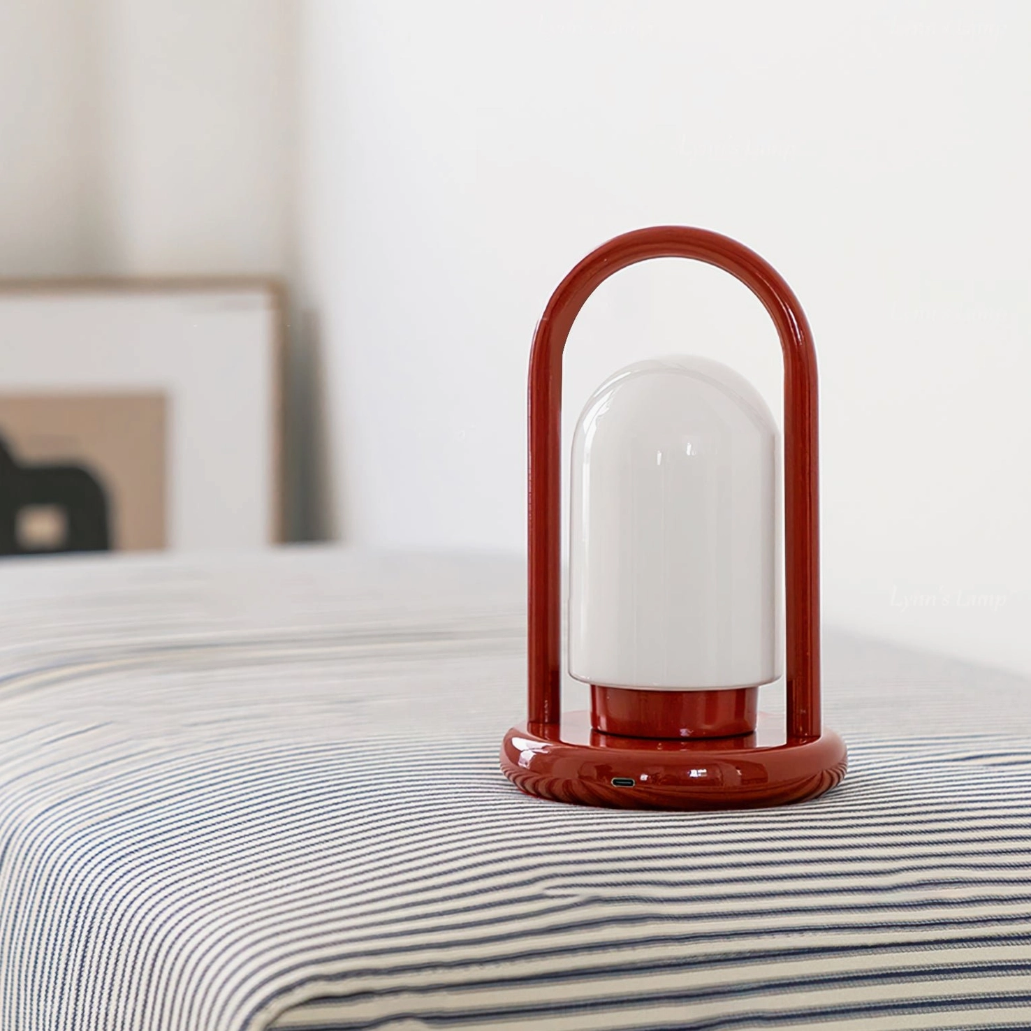 Kero cordless table lamp front view on striped bedding with wall art, modern minimalist aesthetic