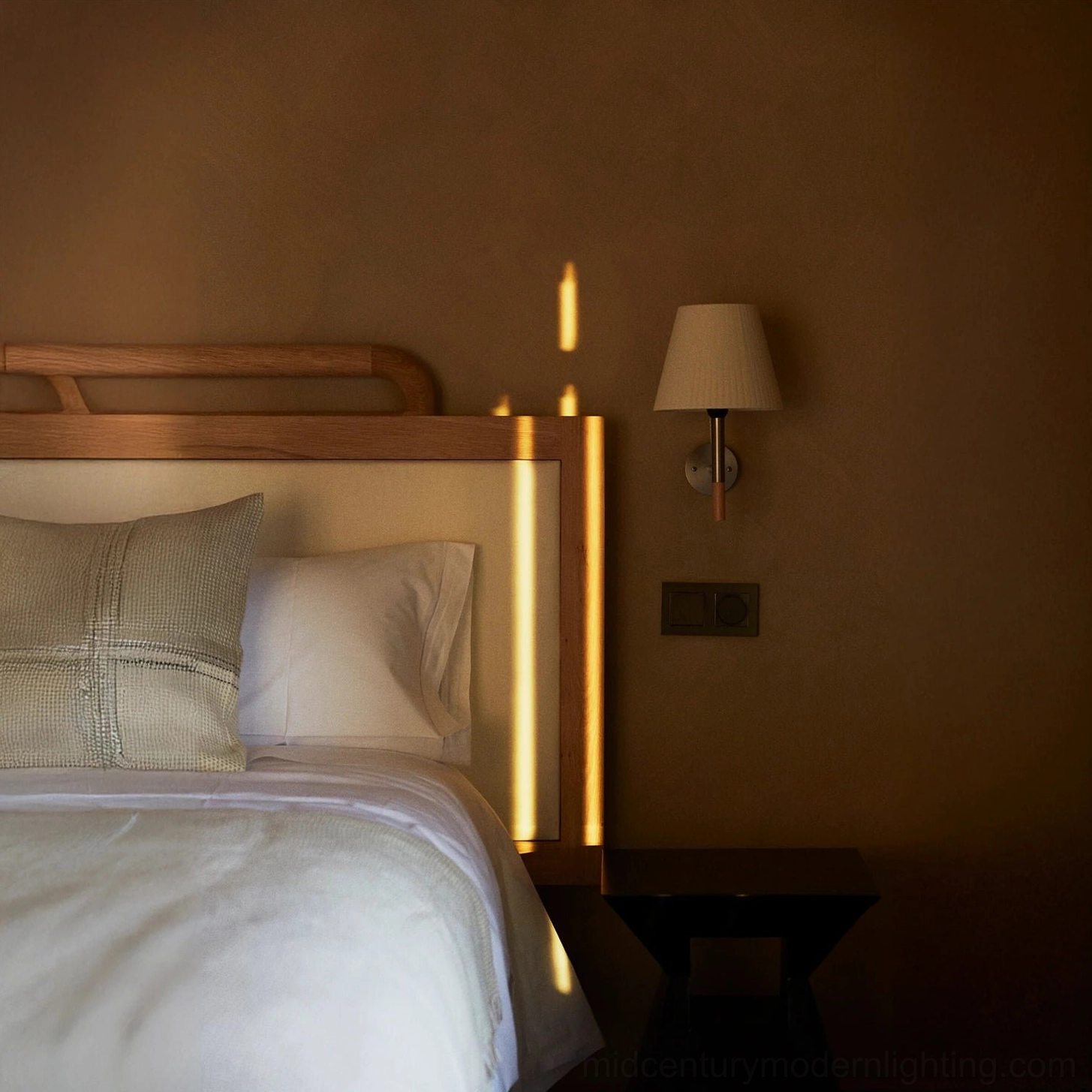 Kilkee wall lamp creating soft shadow effect on bedroom wall with warm ambient illumination