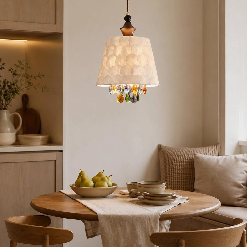 Kitchen dining pendant lamp in warm neutral space with light wood cabinets, cozy throw pillows, and simple table setting