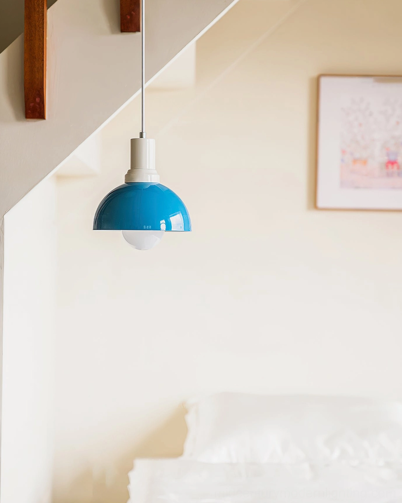 Kleine blue pendant light in minimalist attic bedroom – contemporary Scandinavian design with white bedding and muted tones