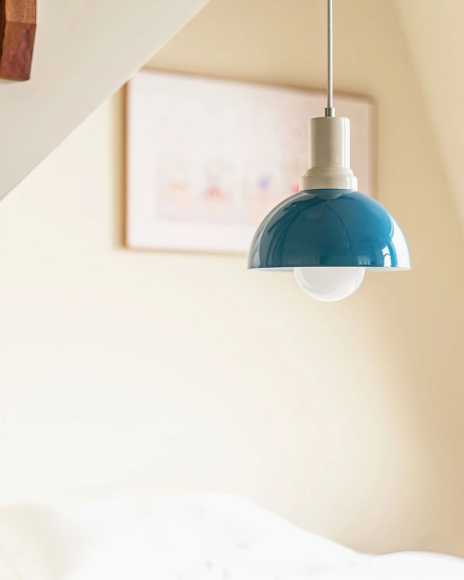Close-up of Kleine teal blue dome pendant with exposed Edison bulb – clean neutral attic interior with framed gallery wall