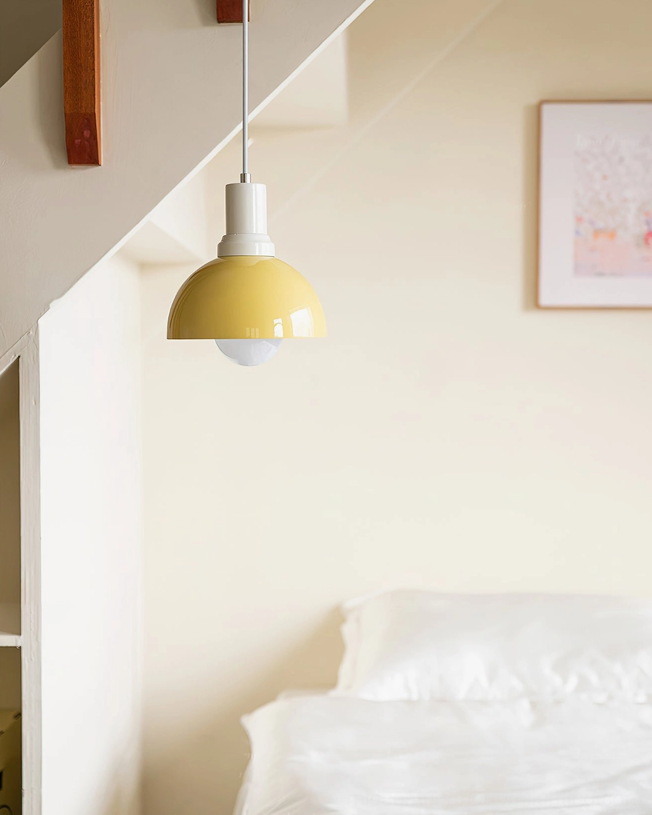 Yellow Kleine pendant lamp hanging in cozy attic bedroom – Scandinavian minimalist interior design aesthetic