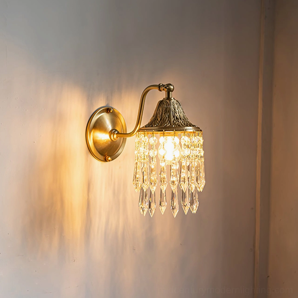 Kristall crystal wall lamp illuminated with warm yellow light casting soft glow and shadows through crystal pendants