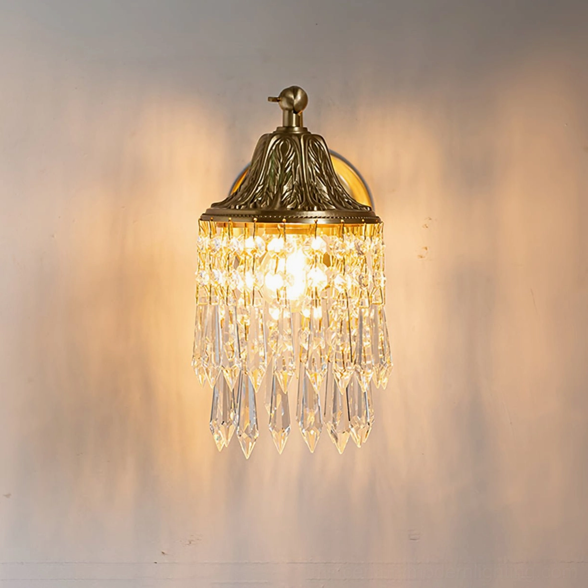 Kristall wall lamp lit detail showing light refraction through crystal tassel pendants creating ambient illumination