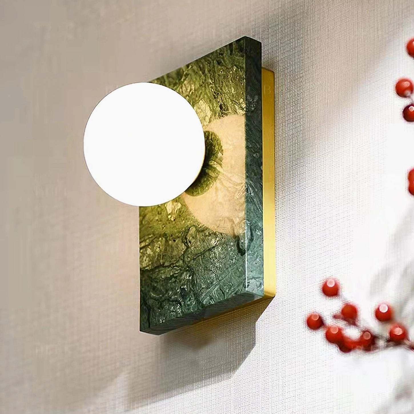 Contemporary marble wall lamp three-quarter view with red berry decor accent - luxury modern interior styling