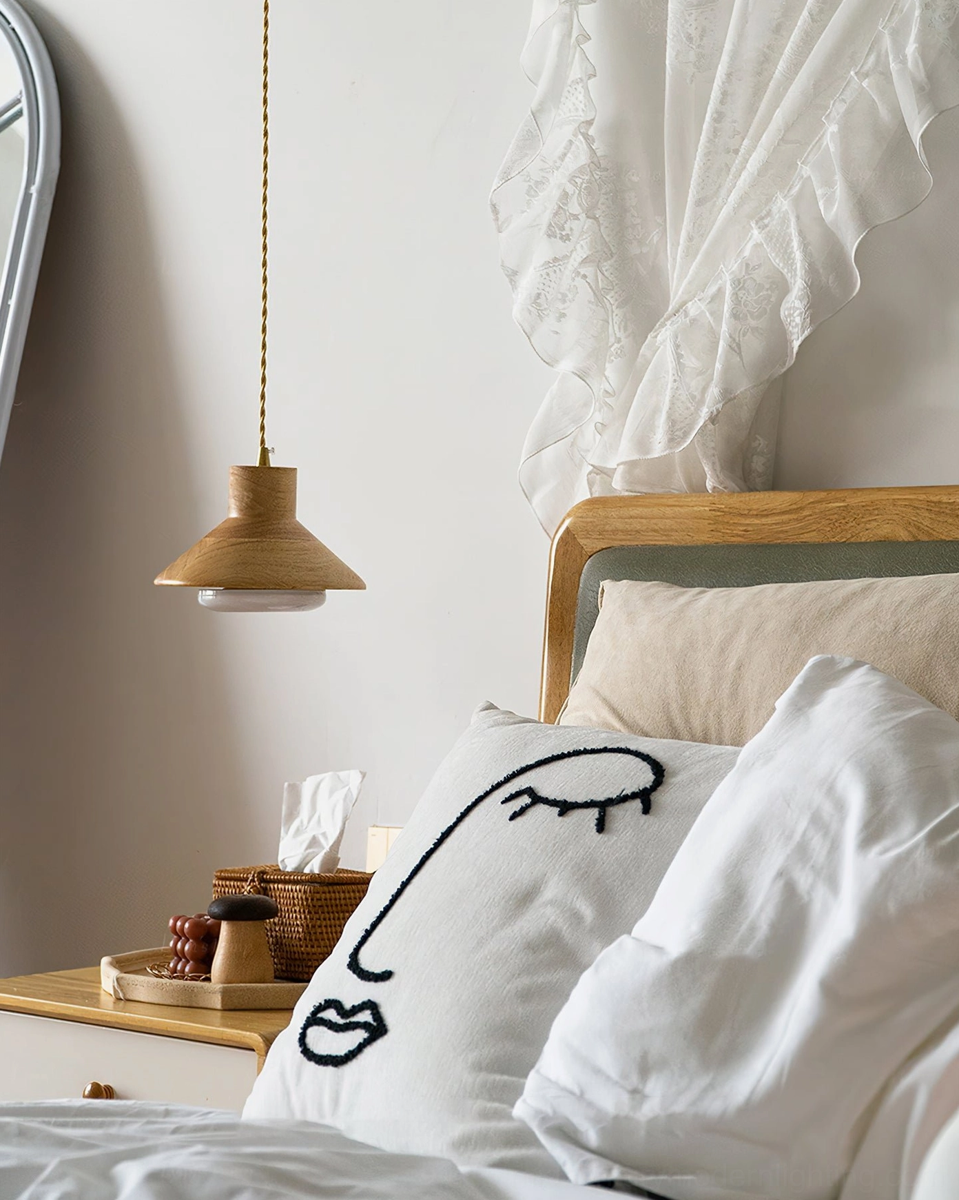 Lander pendant light in bedroom setting with decorative throw pillows and abstract embroidery
