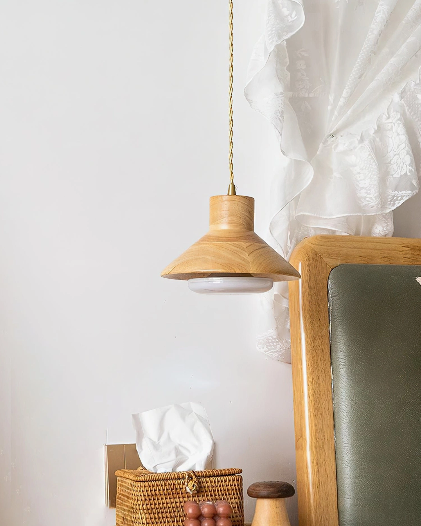 Side view of Lander pendant with twisted power cord hanging above minimalist bedroom headboard