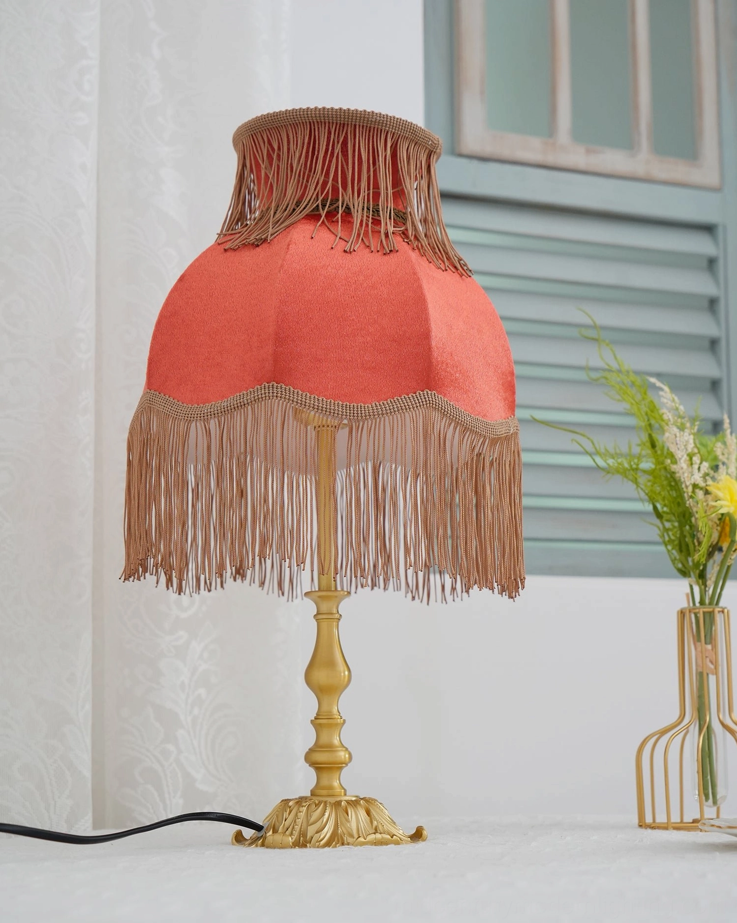 Lanna tassel lamp warm ambient glow red shade on wooden table interior design styling close-up